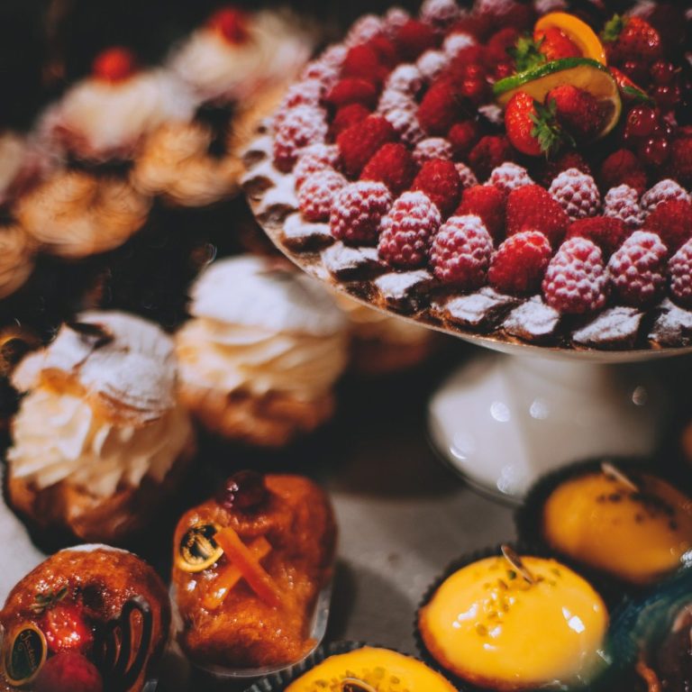 table rempli de pâtisserie (fraise, gâteaux au chocolat, gâteaux au citron,...)